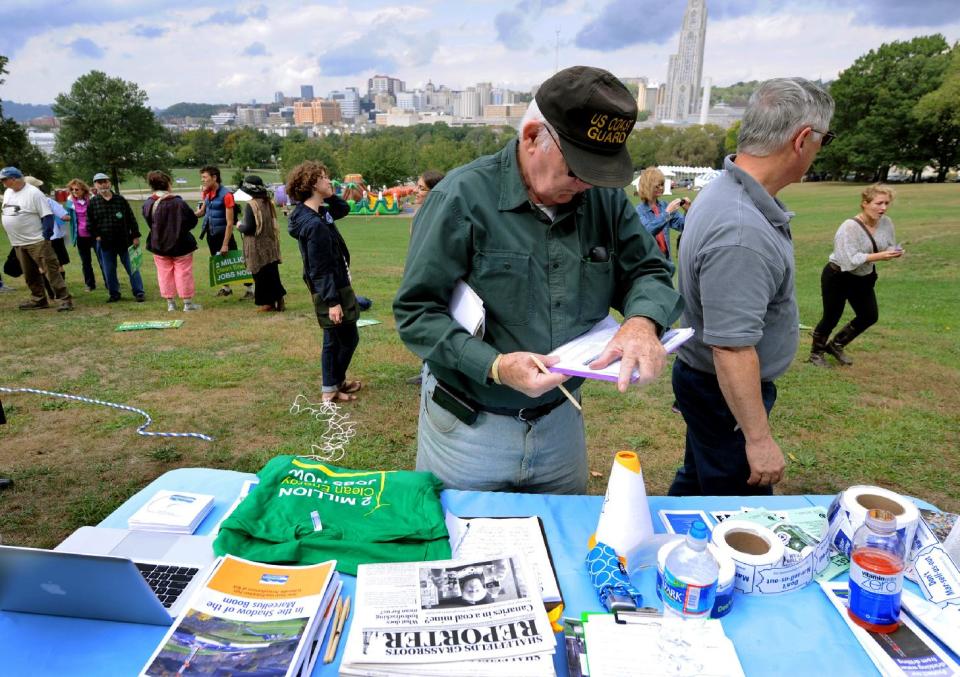 A man signs a petition during a global Frackdown Day calling for a moratorium on Shale Gas Drilling at Schenley Park in Pittsburgh, Saturday, Sept. 22, 2012. (AP Photo/John Heller)