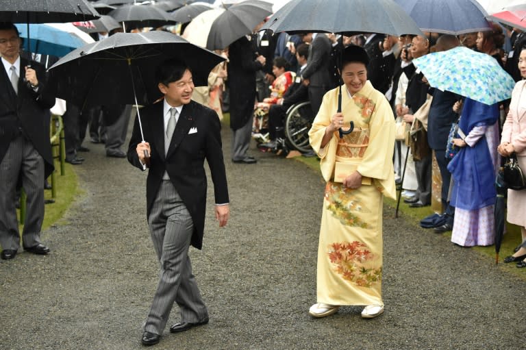 Japan's Crown Prince Naruhito (L) and Crown Princess Masako (R) greet guests during an autumn garden party at Akasaka Palace Imperial garden in Tokyo