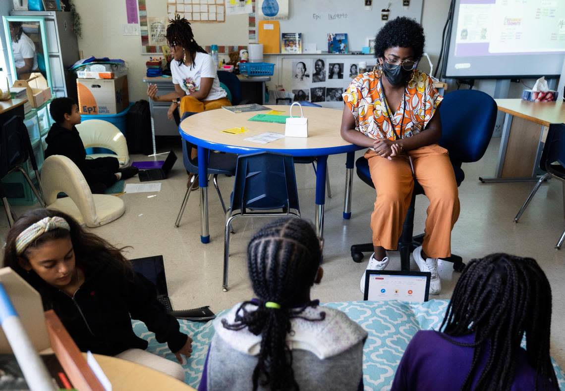 Texas Wesleyan University resident teacher Diamond Tate, right, helps students during book club in a fourth-grade class on Oct. 6, 2022, at the Leadership Academy at John T. White Elementary School.