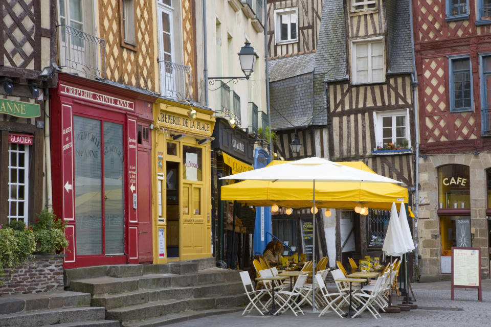 Colorful buildings and a cafe in a square in Rennes, France.