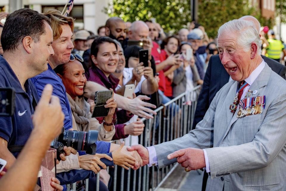 Charles shakes hands with onlookers as he arrives for the inauguration of the St Eusebius Church tower following the commemorative parachute jump and ceremony (AFP/Getty Images)