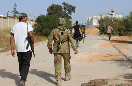 Members of the Libyan internationally recognised government forces walk at Khallat Farjan area in Tripoli, Libya April 20, 2019. REUTERS/Ayman al-Sahili