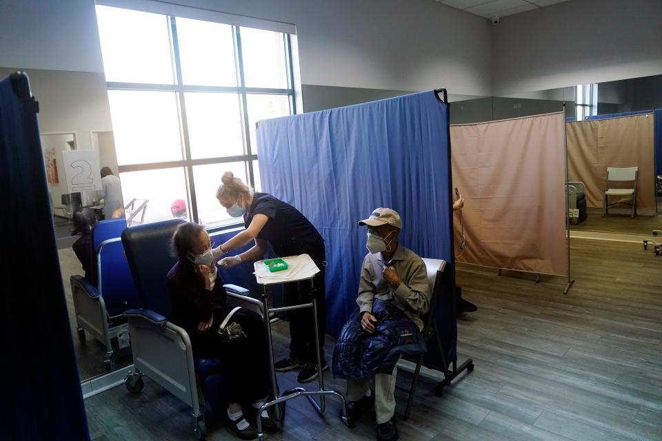 Patients receive a dose of Pfizer's COVID-19 vaccine at Families Together of Orange County Community Health Center, Friday, Feb. 26, 2021, in Tustin, Calif.