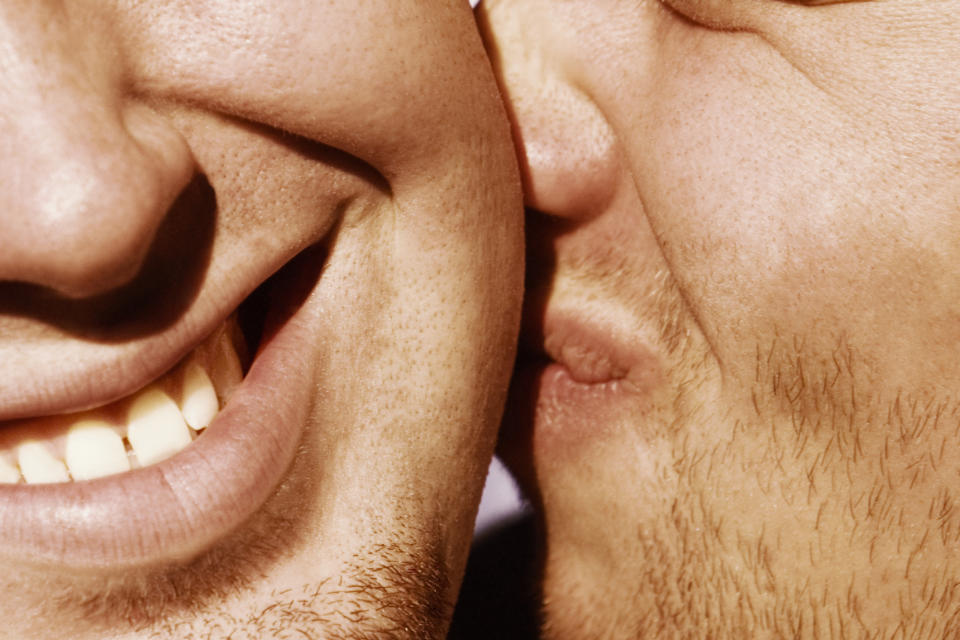 A man kissing another man on the cheek