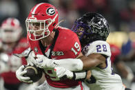 TCU safety Millard Bradford (28) tackles Georgia tight end Brock Bowers (19) during the first half of the national championship NCAA College Football Playoff game, Monday, Jan. 9, 2023, in Inglewood, Calif. (AP Photo/Ashley Landis)