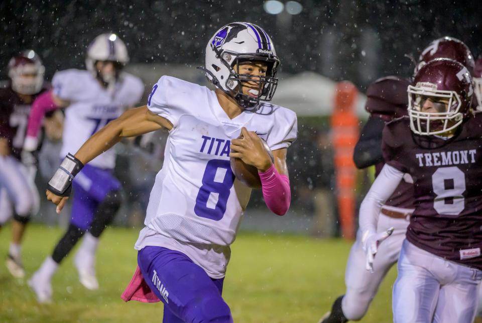 El Paso-Gridley's Kamren Schumacher bolts through the pouring rain and the Tremont defense for a touchdown on the first play from scimmage Friday, Oct. 14, 2022 in Tremont. The Titans ran over the Turks 34-8.