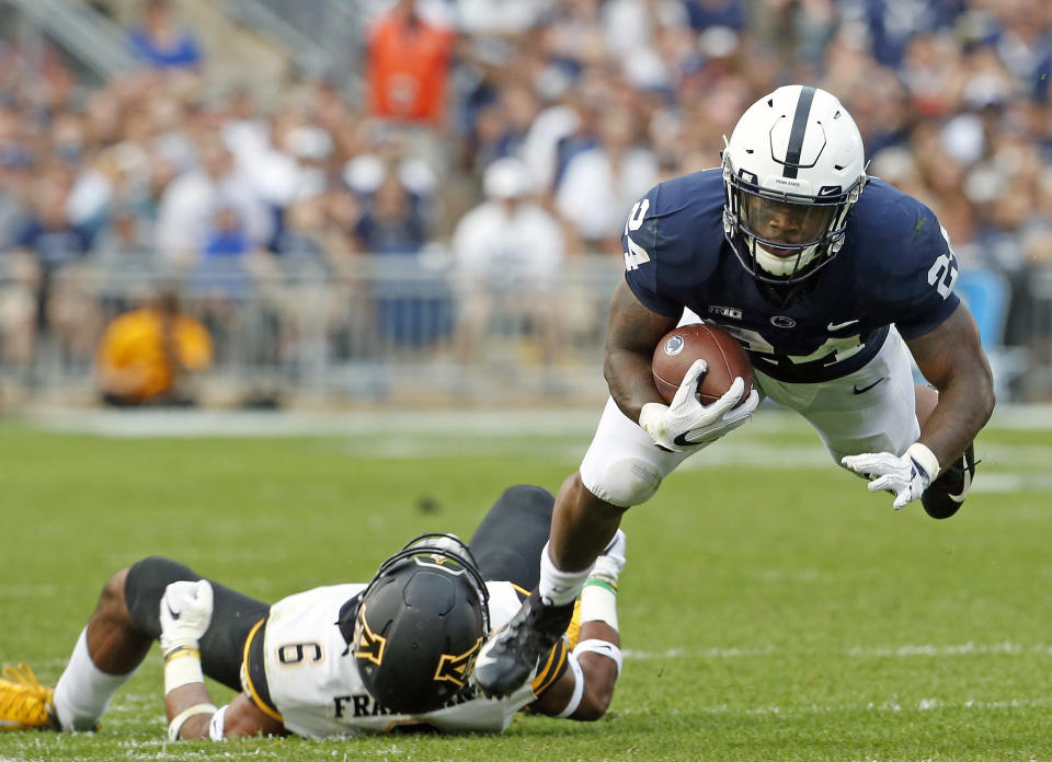 Penn State's Miles Sanders (24) dives for extra yardage after being tackled by Appalachian State's Desmond Franklin (6) during the second half of an NCAA college football game in State College, Pa., Saturday, Sept. 1, 2018. Penn State won 45-38 in OT. (AP Photo/Chris Knight)