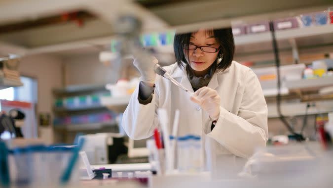 Asian Scientist Pipetting at a Biomedical Laboratory - Image.