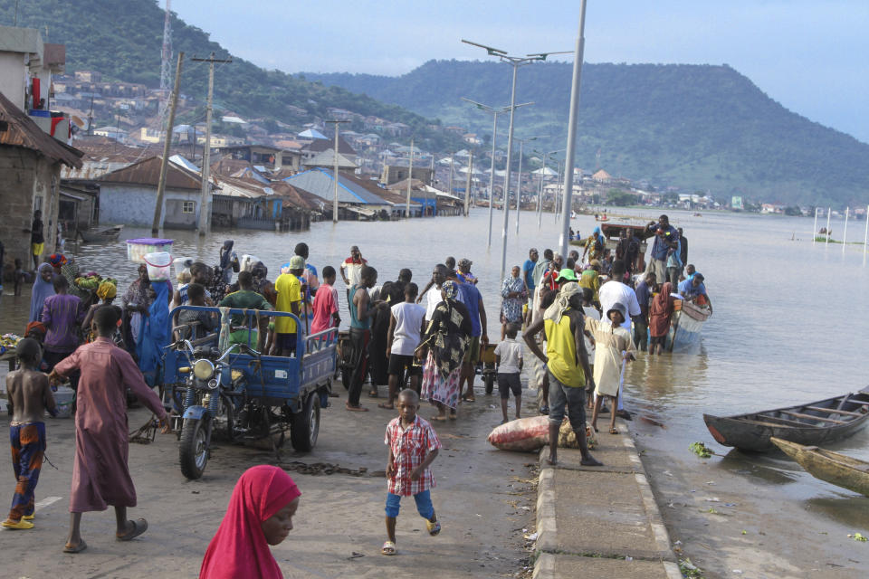 FILE- People stranded due to floods following several days of downpours In Kogi Nigeria, on Oct. 6, 2022. Nigerian state gas company has declared a force majeure after floods hindered gas operations, raising concerns among analysts about the West African nation's capacity to meet local and international demands. (AP Photo/Fatai Campbell, File)