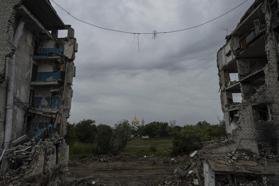 A church can be seen in the distance through an apartment building destroyed by an airstrike in the recently liberated town of Izium, Ukraine, Thursday, Sept. 15, 2022. Izium served as a hub for Russian soldiers for nearly seven months, during which they established torture sites throughout the city. (AP Photo/Evgeniy Maloletka)