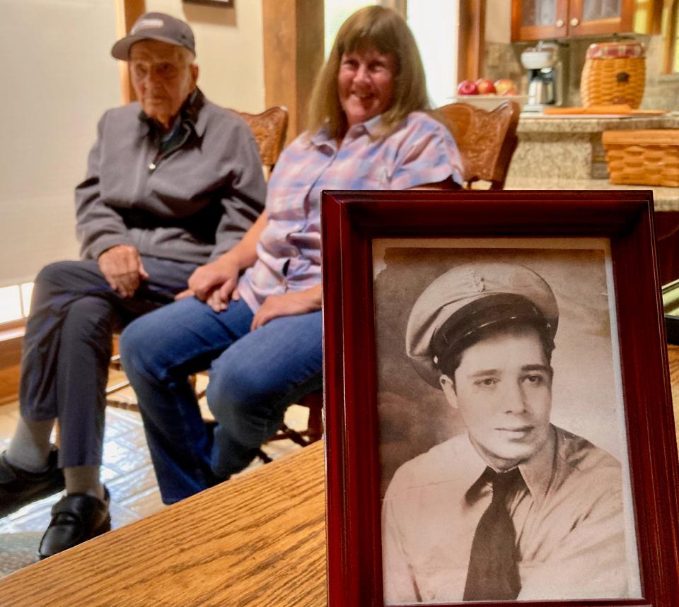 A picture of Mario Pennesi in his Navy uniform in 1942 with the World War II veteran, now 104, and one of his caregivers, Dottie Dean, sitting in the background.