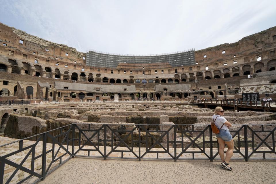 A visitor poses in front of the newly restored lower level of the Colosseum, during an event for the media, in Rome, Friday, June 25, 2021. After 2-and-1/2 years of work to shore up the Colosseum’s underground passages, tourists will be able to go down and wander through part of what what had been the ancient arena’s “backstage.” (AP Photo/Andrew Medichini)