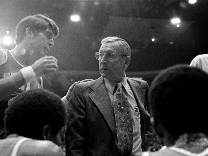 UCLA basketball coach John Wooden listens to Greg Lee, left, during a timeout against Iowa on Jan. 17, 1974, in Chicago.