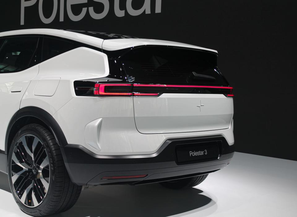 The rear of a white Polestar 3 electric SUV, with a red brake light strip across its hatch.