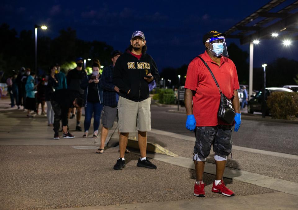 Val Dudley, right, waits in line to vote Nov. 3, 2020, at the Tempe History Museum polling place in Arizona.
