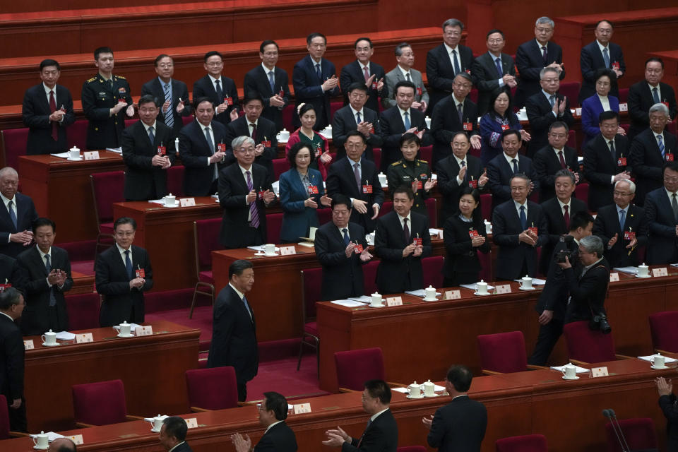 Delegates applaud as Chinese President Xi Jinping and Premier Li Qiang arrive for the second plenary session of the National People's Congress (NPC) at the Great Hall of the People in Beijing, Friday, March 8, 2024. (AP Photo/Andy Wong)