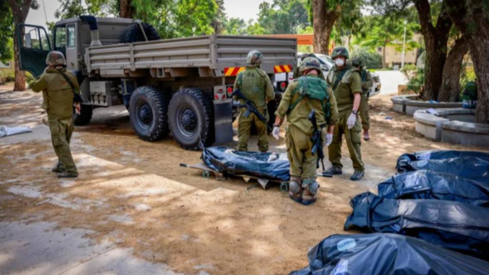 以色列軍方從社區中撤出遺體。（圖／翻攝自《i24 New》）