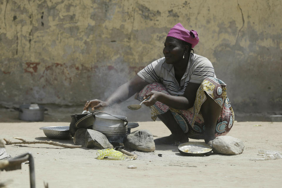 In this photo taken on Thursday, Feb. 21, 2019, A woman displaced by Islamist extremist prepares a meal at Malkohi camp in Yola, Nigeria. For those who live in the makeshift camp for Nigerians who have fled Boko Haram violence, the upcoming presidential vote isn’t a topic of conversation, because nearly all are more worried about putting food on the table. (AP Photo/ Sunday Alamba)