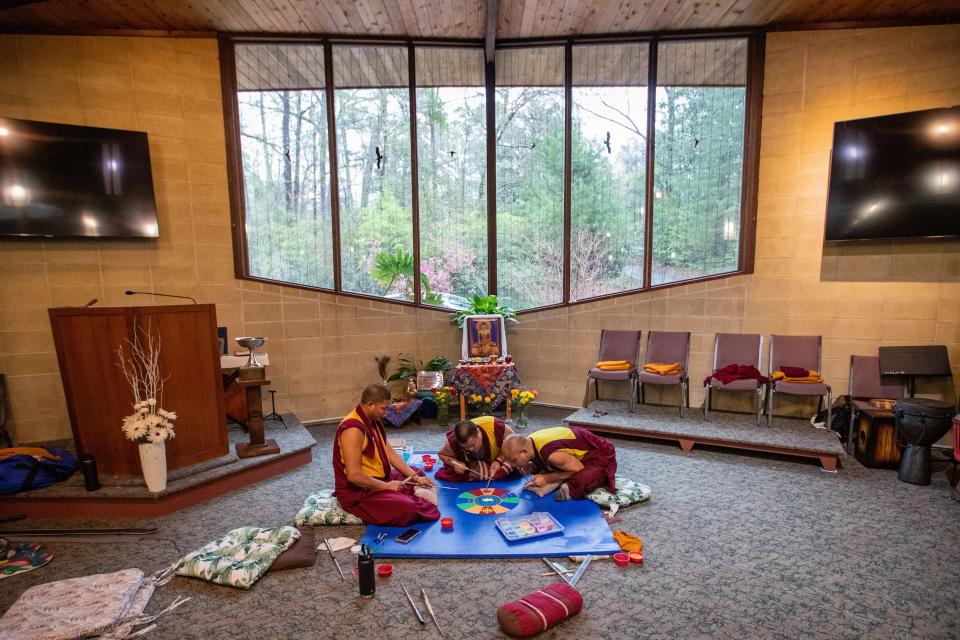 Tibetan Buddhist monks work to create their mandala for world peace at Unitarian Universalist Church on Tuesday, March 5, 2024. They use colored sand and tools to create the intricate design.
