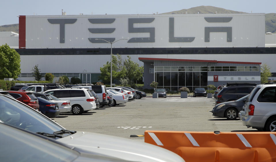 Vehicles are seen parked at the Tesla plant Monday, May 11, 2020, in Fremont, Calif. The parking lot was nearly full at Tesla's California electric car factory Monday, an indication that the company could be resuming production in defiance of an order from county health authorities. (AP Photo/Ben Margot)