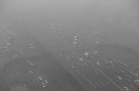 Vehicles drive through the Guomao Bridge on a heavy haze day in Beijing's central business district January 29, 2013. REUTERS/Jason Lee