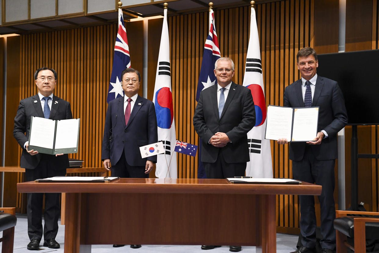 South Korean President Moon Jae-in, second left, and Australian Prime Minister Scott Morrison, second right, pose for photographs with South Korean Trade Minister Yeo Han-koo, left, and Australian Energy Minister Angus Taylor during a signing ceremony signing ceremony at Parliament House, in Canberra, Australia, Monday, Dec. 13, 2021. Moon is on a two-day official visit to Australia. (Lukas Coch/Pool Photo via AP)