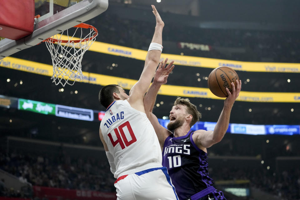 Sacramento Kings forward Domantas Sabonis, right, drives against Los Angeles Clippers center Ivica Zubac during the first half of an NBA basketball game, Sunday, Feb. 25, 2024, in Los Angeles. (AP Photo/Ryan Sun)