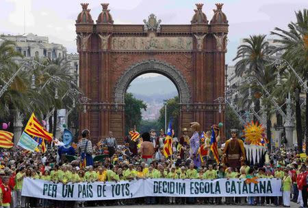 Demonstrators carry a banner, which reads: "Decided, Catalan school", in Barcelona in this June 14, 2014 file photograph. For 30 years, public schools in Spain's Catalonia region have taught most subjects in Catalan, not the national Castilian Spanish language. REUTERS/Gustau Nacarino/Files