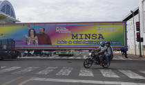 A motorcyclist rides past a truck billboard promoting President Daniel Ortega and his wife and Vice President Rosario Murillo, in Managua, Nicaragua, Thursday, June 17, 2021. In recent weeks, Nicaragua President Daniel Ortega's government has rounded up 13 opposition leaders, including four presidential challengers for the Nov. 7 elections. They face allegations ranging from money laundering to crimes against the state. (AP Photo/Miguel Andres)