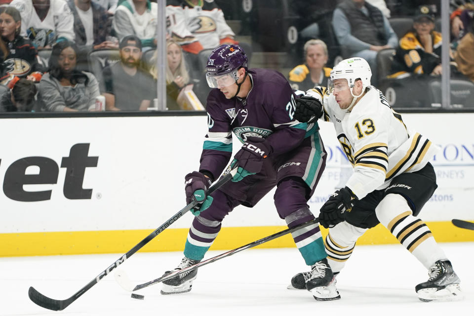 Boston Bruins center Charlie Coyle, right, and Anaheim Ducks right wing Brett Leason, left, vie for the puck during the first period of an NHL hockey game Sunday, Oct. 22, 2023, in Anaheim, Calif. (AP Photo/Ryan Sun)