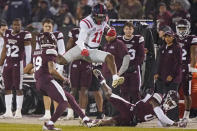 Mississippi wide receiver Dontario Drummond (11) leaps over fallen Mississippi safety Jalen Green for a first down during the first half of an NCAA college football game Thursday, Nov. 25, 2021, in Starkville, Miss. (AP Photo/Rogelio V. Solis)