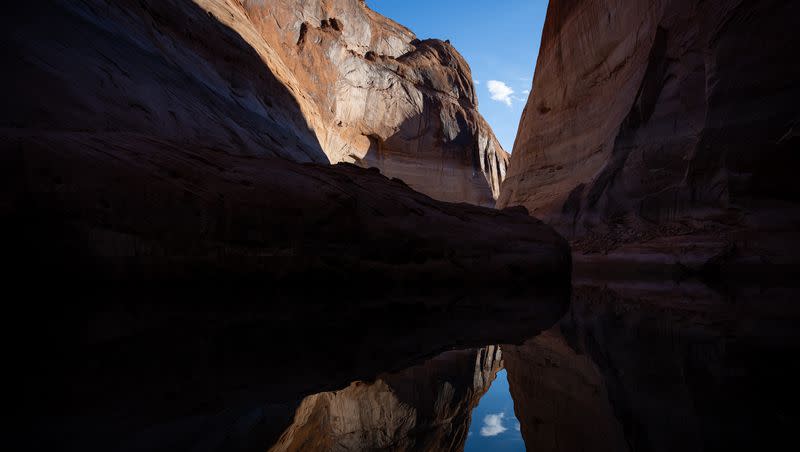 Light and shadows on the canyon walls of Davis Gulch, a side canyon on the Escalante River arm of Lake Powell, are reflected in the reservoir’s waters on Friday, Oct. 7, 2022.