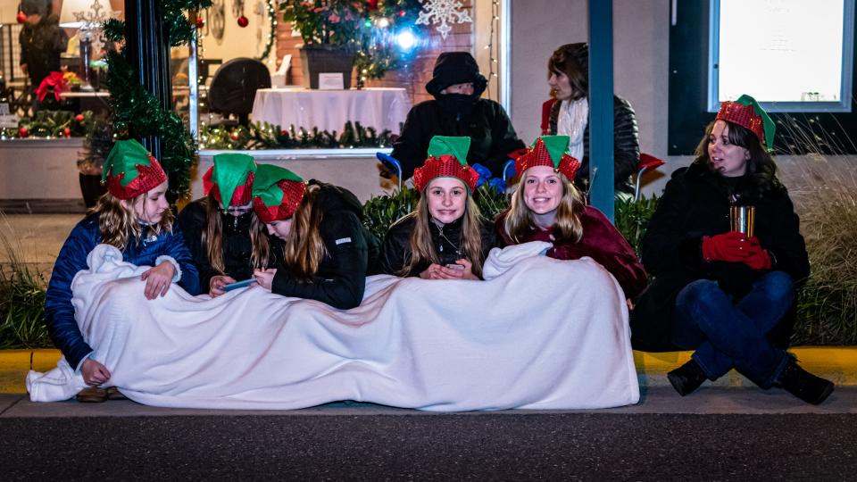 Young parade attendees are bundled up for the chilly night as they settle in to watch the Chincoteague Christmas parade roll by.