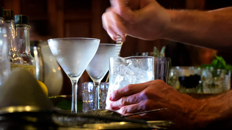 A bartender's hands stirring a cocktail