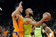 Minnesota Timberwolves guard Jaylen Nowell (4) shoots as Phoenix Suns guard Devin Booker, left, defends during the first half of an NBA basketball game, Friday, Jan. 28, 2022, in Phoenix. (AP Photo/Matt York)