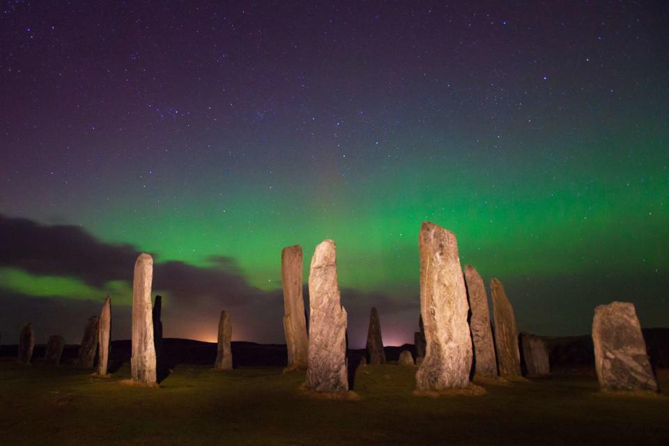 <p>RichardALock/Getty Images</p> The Northern Lights over the Callanish Stones of Lewis and Harris, a Scottish island in the Outer Hebrides