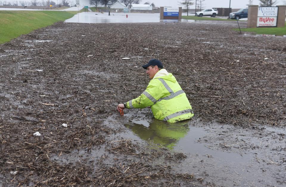 Mat Kahler, an employee of the City of Huxley, works to remove the drain clog to clear the water after heavy rainfall throughout the morning that created a flash flood on HWY 69 on Friday, April 22, 2022, in Huxley, Iowa.