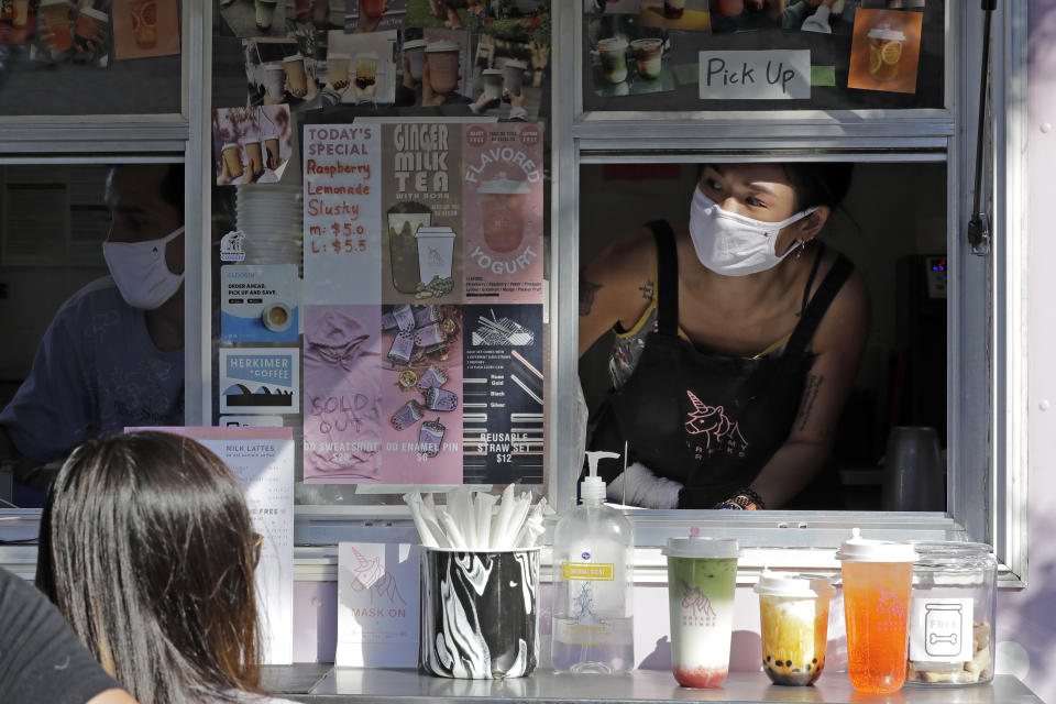 Kaye Fan, right, calls out orders as she works in her Dreamy Drinks food truck, Monday, Aug. 10, 2020, near the suburb of Lynnwood, Wash., north of Seattle. Long seen as a feature of city living, food trucks are now finding customers in the suburbs during the coronavirus pandemic as people are working and spending most of their time at home. (AP Photo/Ted S. Warren)