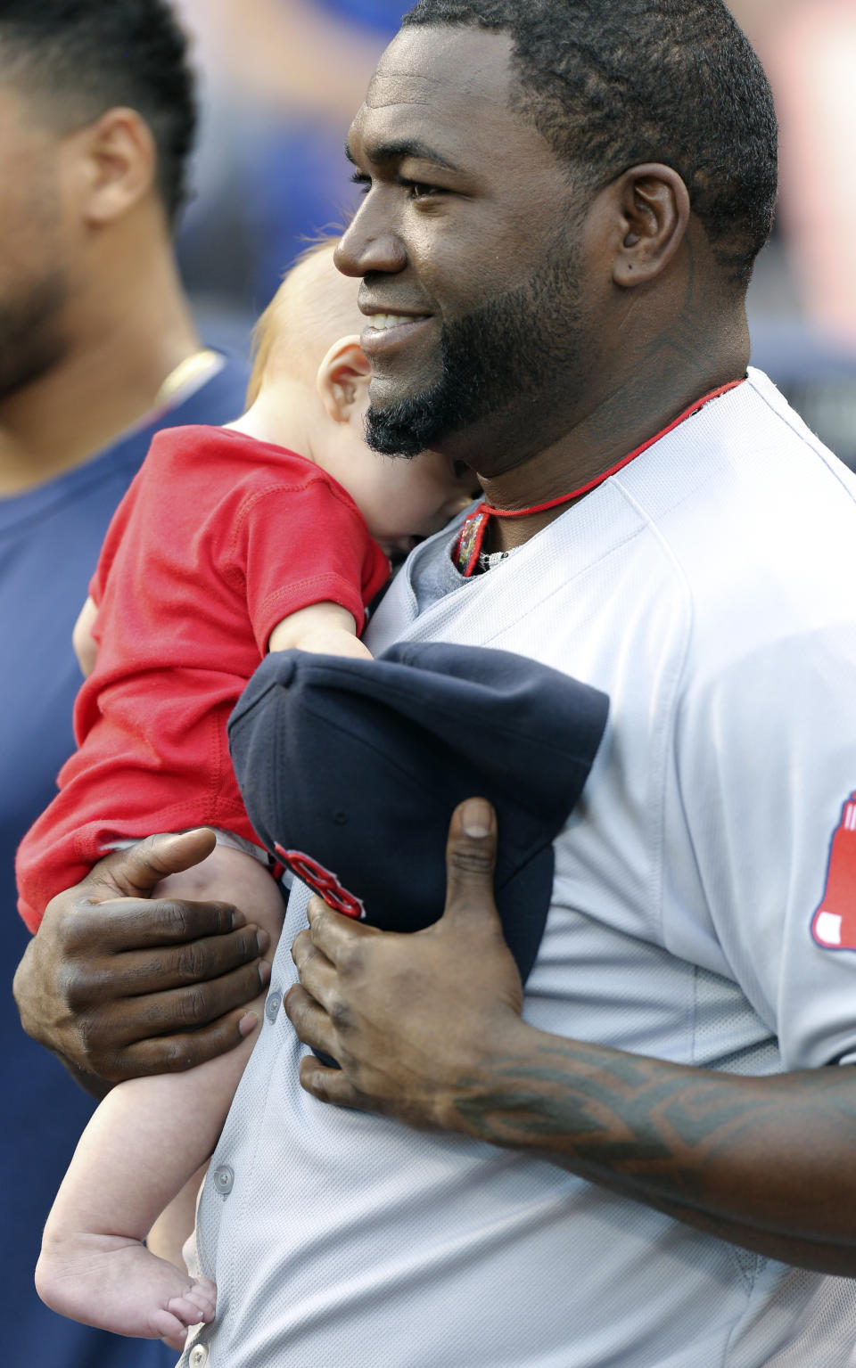 KANSAS CITY, MO - AUGUST 8:   David Ortiz #34 of the Boston Red Sox holds a fan's child during the singing of the 'National Anthem' prior to a game against the Kansas City Royals at Kauffman Stadium August, 8, 2013 in Kansas City, Missouri.  (Photo by Ed Zurga/Getty Images)