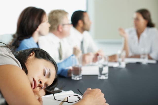 Businesswoman sleeping in conference room during meeting