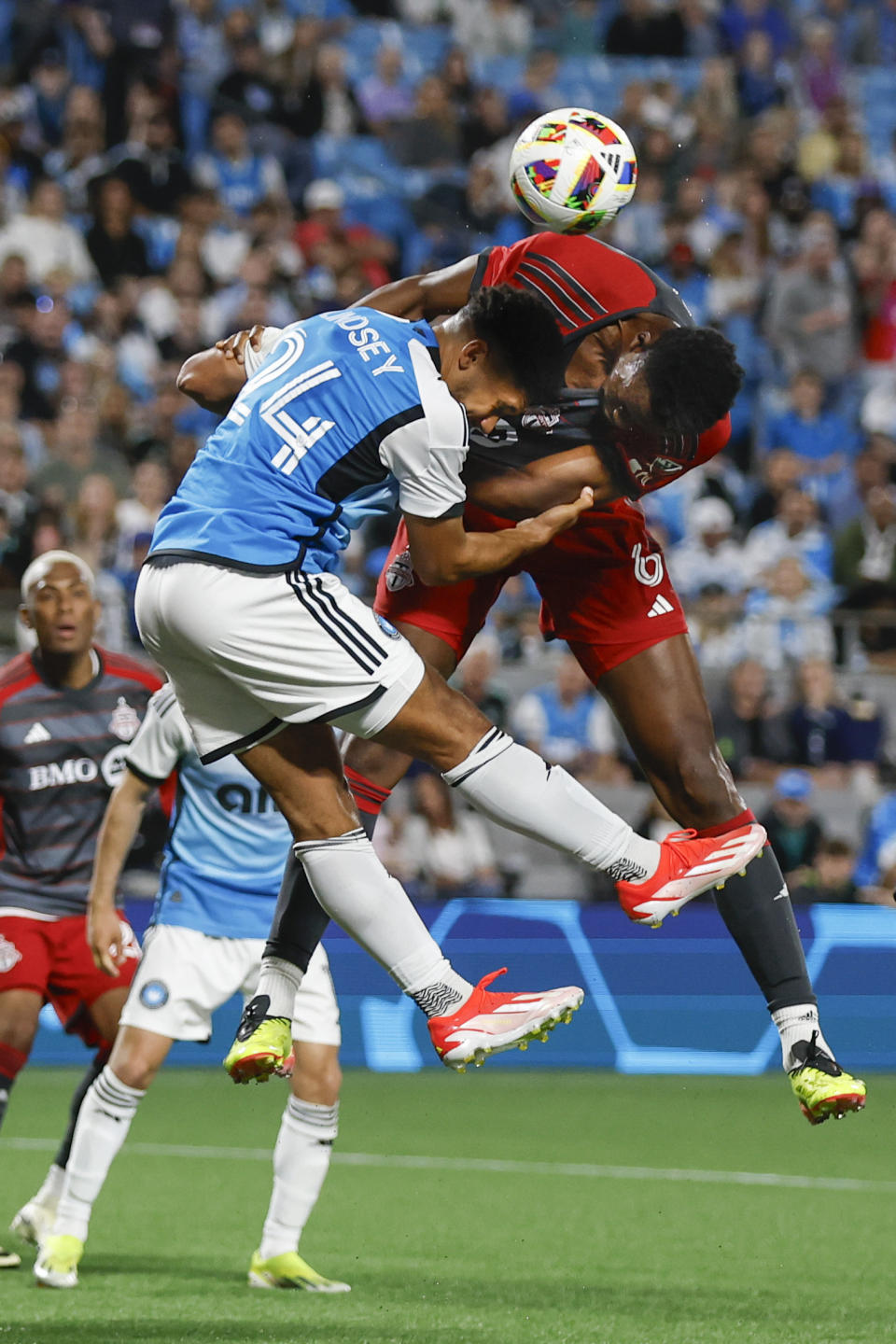 Toronto FC defender Aime Mabika, right, collides with Charlotte FC defender Jaylin Lindsey on a second-half corner kick during an MLS soccer match in Charlotte, N.C., Saturday, April 13, 2024. (AP Photo/Nell Redmond)