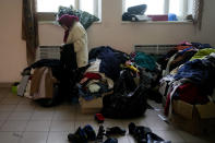 A woman who lost her home looks at donated cloths at a Sanatorium working as temporary place for people without a home Irpin, outskirts Kyiv, Ukraine, Thursday, May 26, 2022. (AP Photo/Natacha Pisarenko)