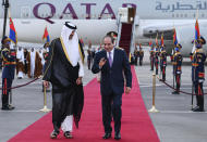 In this photo provided by Egypt's presidency media office, Egyptian President Abdel-Fattah el-Sissi, right, accompanies Qatari Emir Tamim bin Hamad Al Thani upon his arrival at Cairo airport, Egypt, Friday, June 24, 2022. (Egyptian Presidency Media Office via AP)