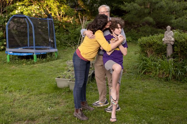Jennifer Alonzo and Brian Wells wrestle some kisses onto each other and their daughter, Fischer Wells, in their backyard in Louisville. (Photo: Alton Strupp for HuffPost)