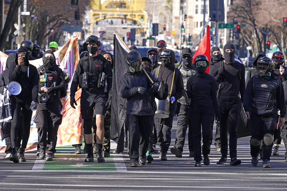 Black clad protesters march to the state Capitol in Sacramento, Calif., Wednesday, Jan. 20, 2021. Several dozen protestors marched through the downtown area to the Capitol where they were stopped at a temporary 6-foot high chain-link fence installed to stop violence on the Inauguration Day of President Joe Biden and Vice President Kamala Harris. (AP Photo/Rich Pedroncelli)