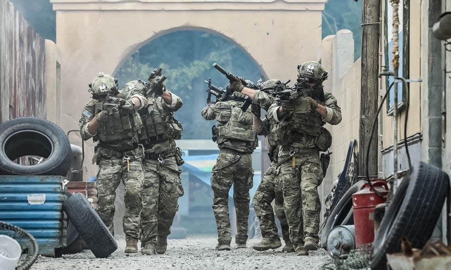 U.S. Army Rangers from 75th Ranger Regiment simulate clearing a village alley in support of the Army Marketing Research Group's "Warriors Wanted" campaign at Fort Campbell, Ky, on July 22, 2018.