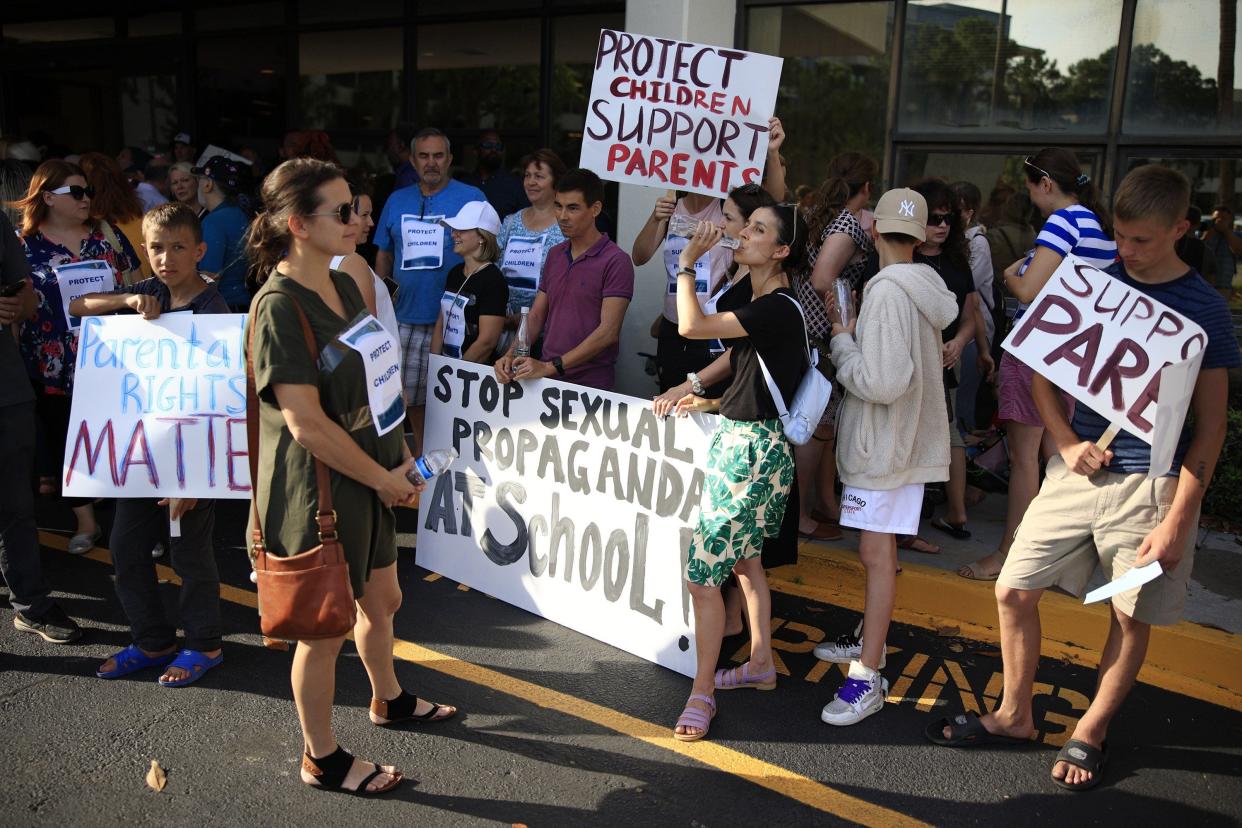 In May 2022 supporters of a recently passed education bill hold signs at the Duval County Public Schools building in Jacksonville.