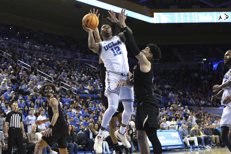 UCLA guard Sebastian Mack (12) goes up to shoot above Colorado guard KJ Simpson, center right, during the second half of an NCAA college basketball game Thursday, Feb. 15, 2024, in Los Angeles. (AP Photo/Raul Romero Jr.)