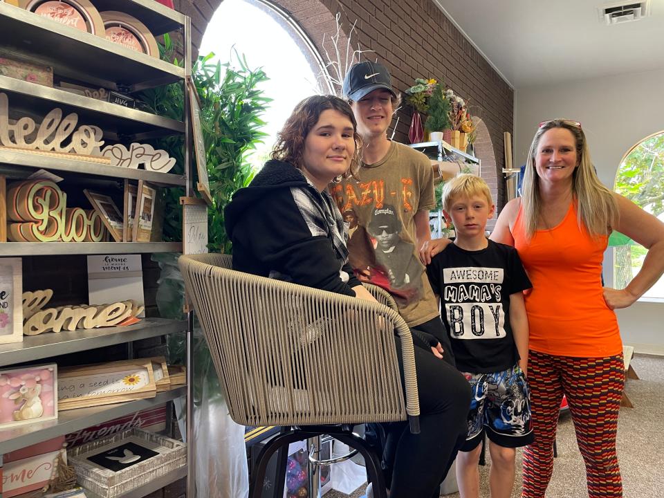 Michelle Walker-Schaefer (right) gathers with three of her children, from left Renee, 23, Nicholas, 21, and Kolton, 8, near the front entrance of Dealz Dealz.