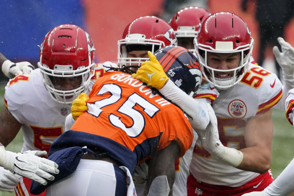 Denver Broncos running back Melvin Gordon (25) is brought down by Kansas City Chiefs linebacker Ben Niemann (56) and others during the first half of an NFL football game Sunday, Oct. 25, 2020, in Denver. (AP Photo/Jack Dempsey)